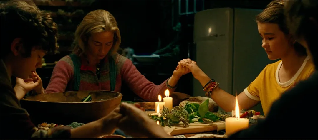 Still image from A Quiet Place showing the Abbott family praying over a meal